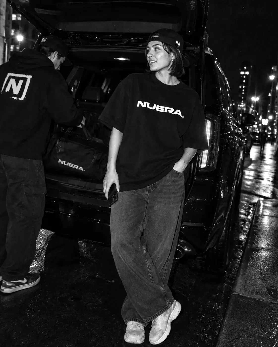 NUERA teammates together beside a vehicle at night