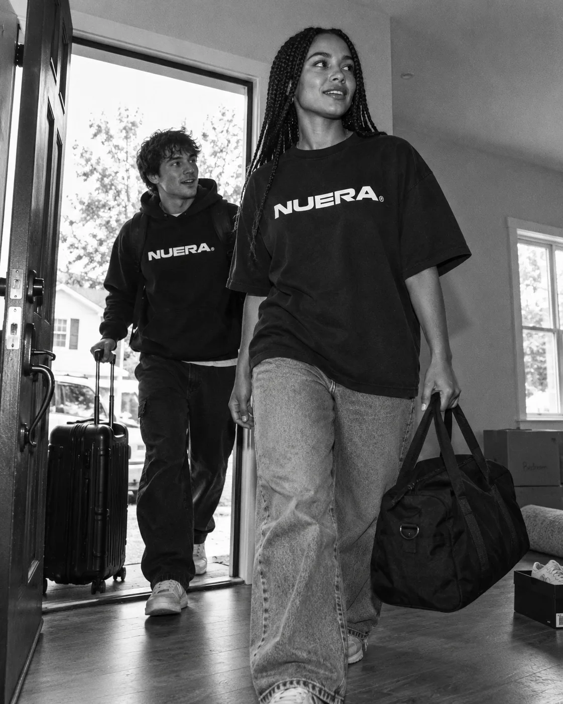 Two people arriving at a house with bags in NUERA oversized streetwear.